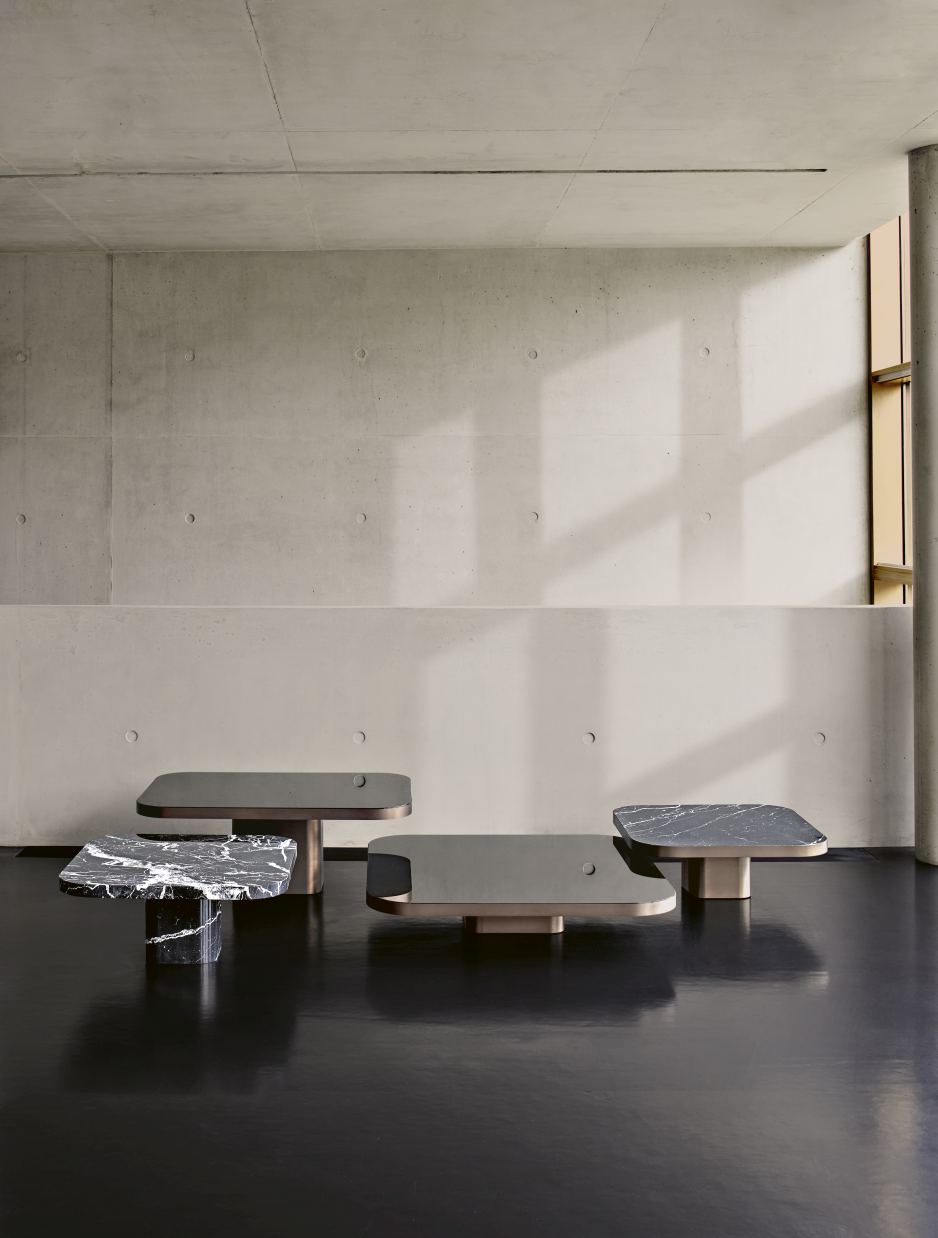 ClassiCon Bow Coffee Table No. 3: Vier moderne Couchtische mit Marmorplatten und minimalistischem Design in einem Raum.