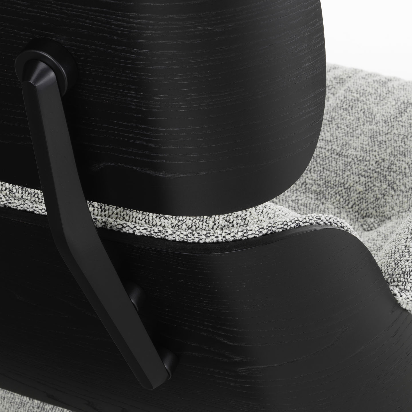 Detailansicht der Rückseite eines schwarzen Eames Lounge Chairs mit grau meliertem Stoffbezug.