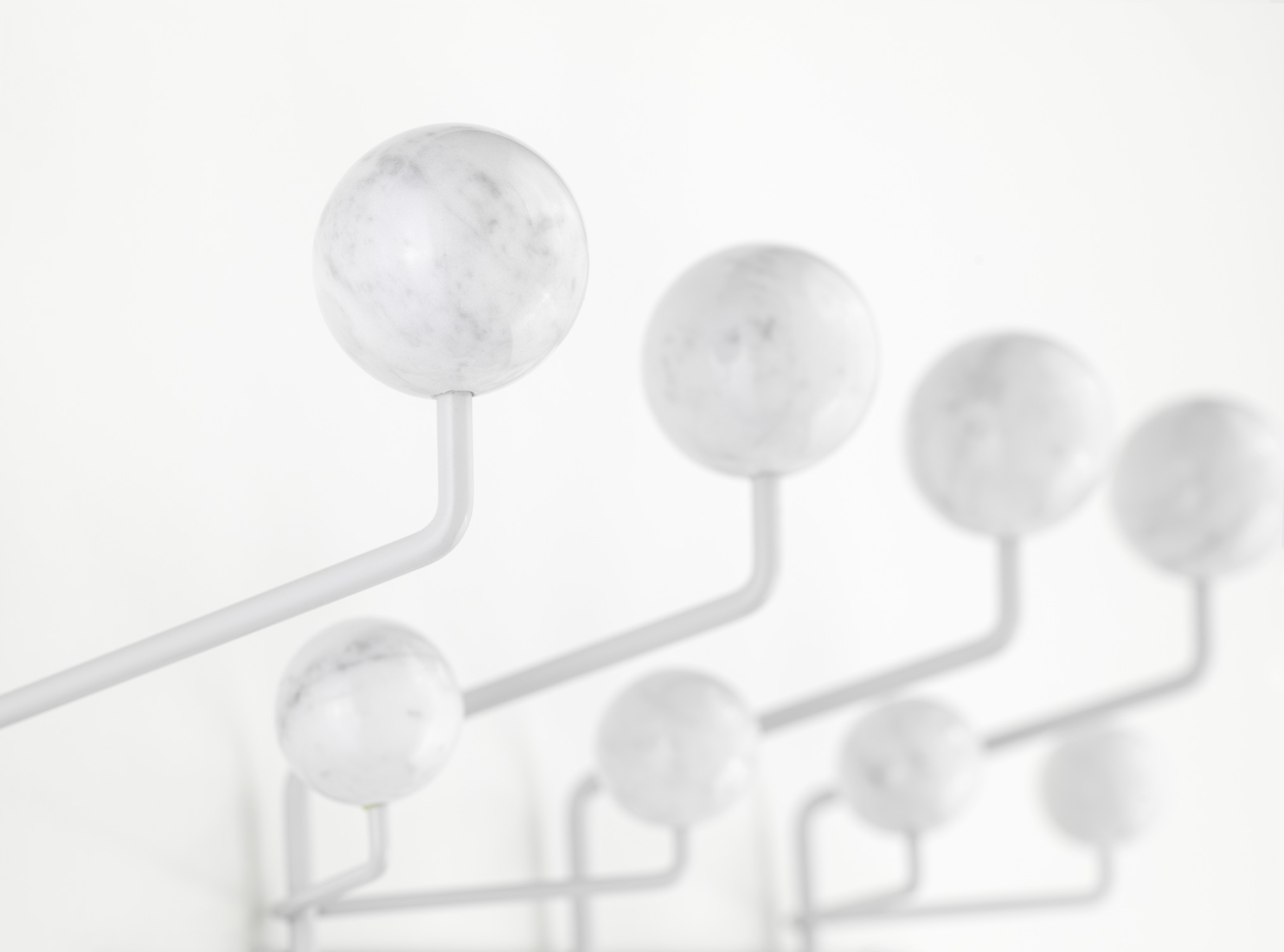 Detailaufnahme der Eames Hang it all Garderobe in Marmor Optik, ein Designklassiker für stilvolle Flure.