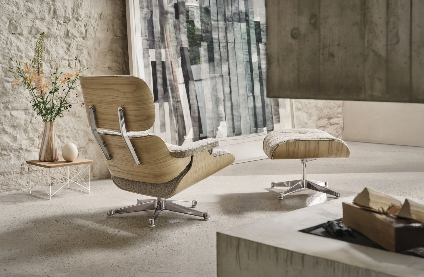 Vitra Eames Lounge Chair mit Ottoman in hellem Holz und Stoffbezug im modernen Wohnzimmer.
