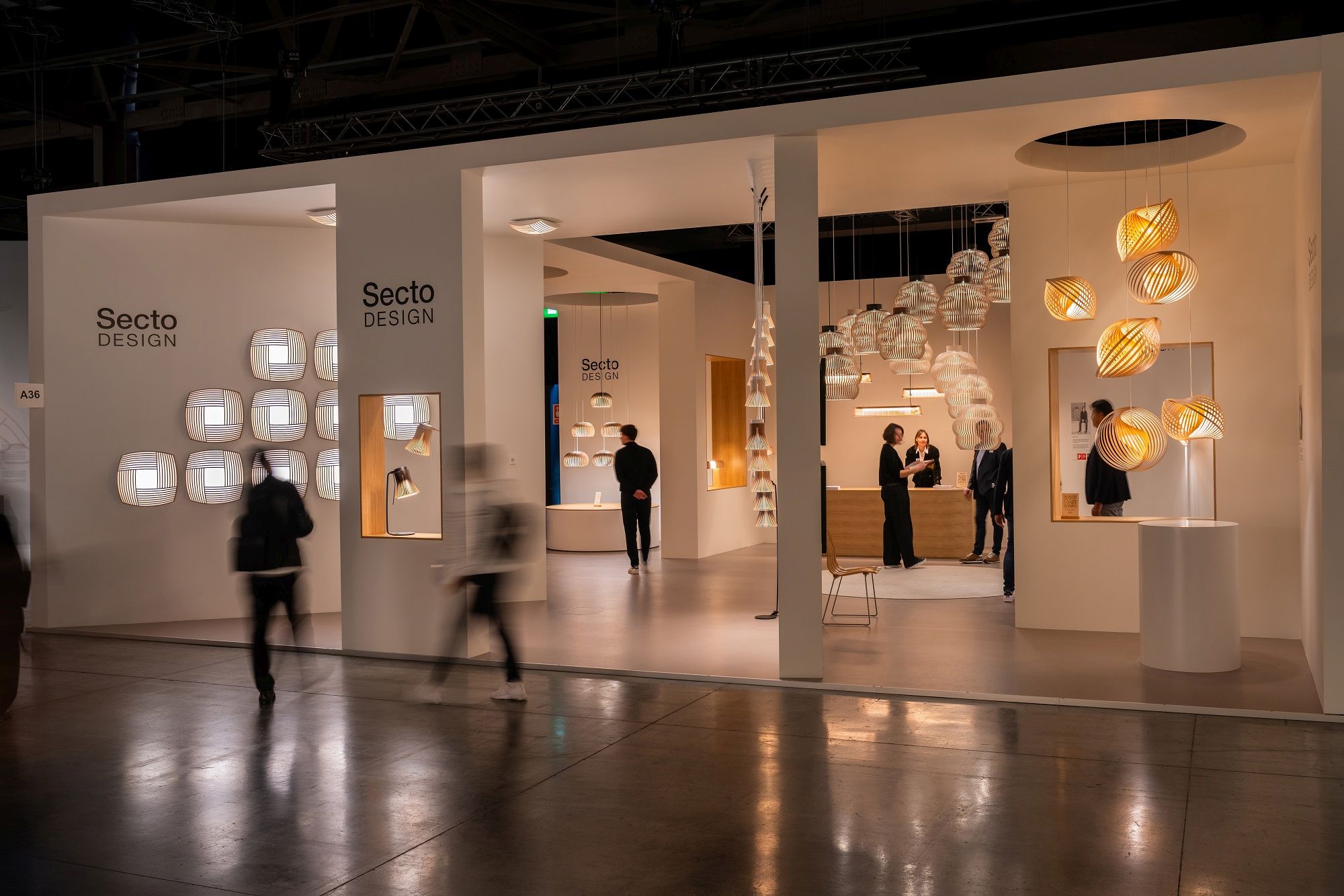 Ausstellung mit verschiedenen Secto Design Leuchten, darunter die Adilo Pendelleuchte aus Holz, modernes skandinavisches Design.