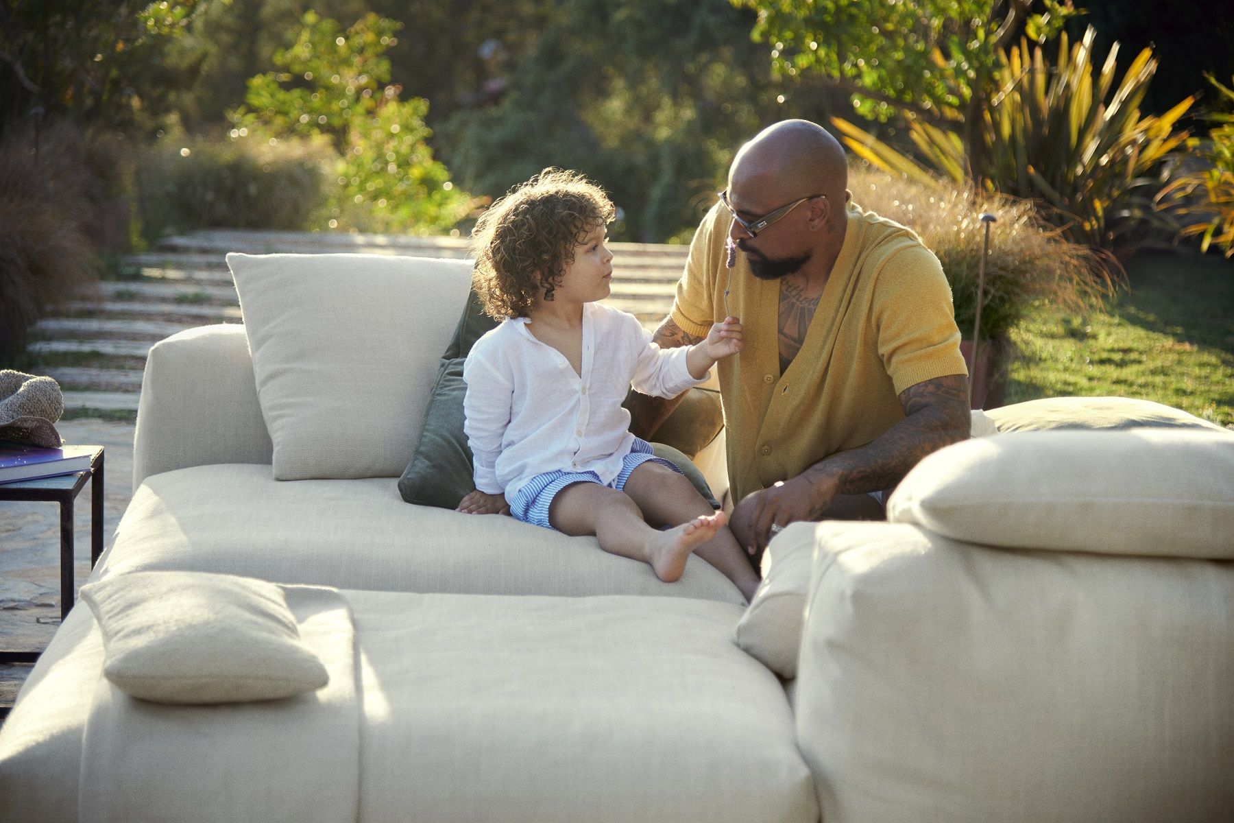 Vater und Kind entspannen auf dem beigen vetsak Sofa Set 08 Outdoor 6-Sitzer im Garten.
