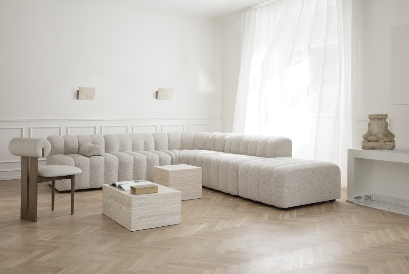 Heller Wohnraum mit Hippo Stuhl von NORR11, modularem Sofa und Couchtischen aus Travertin.