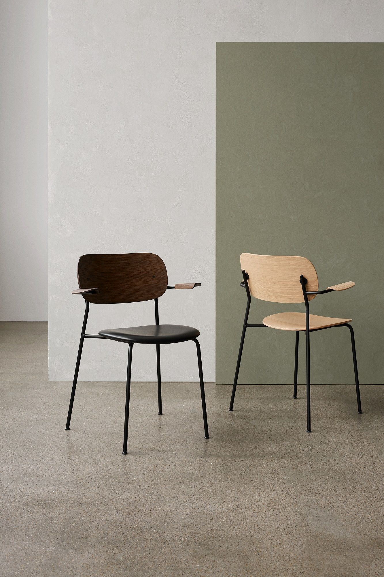 Zwei Co Dining Chair Stühle von Audo Copenhagen mit Armlehnen und schwarzem Metallgestell.