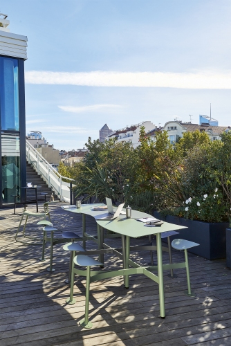Bolder 3-Sitzer Tisch mit Sitzflächen von Fermob für den Außenbereich auf einer Dachterrasse.