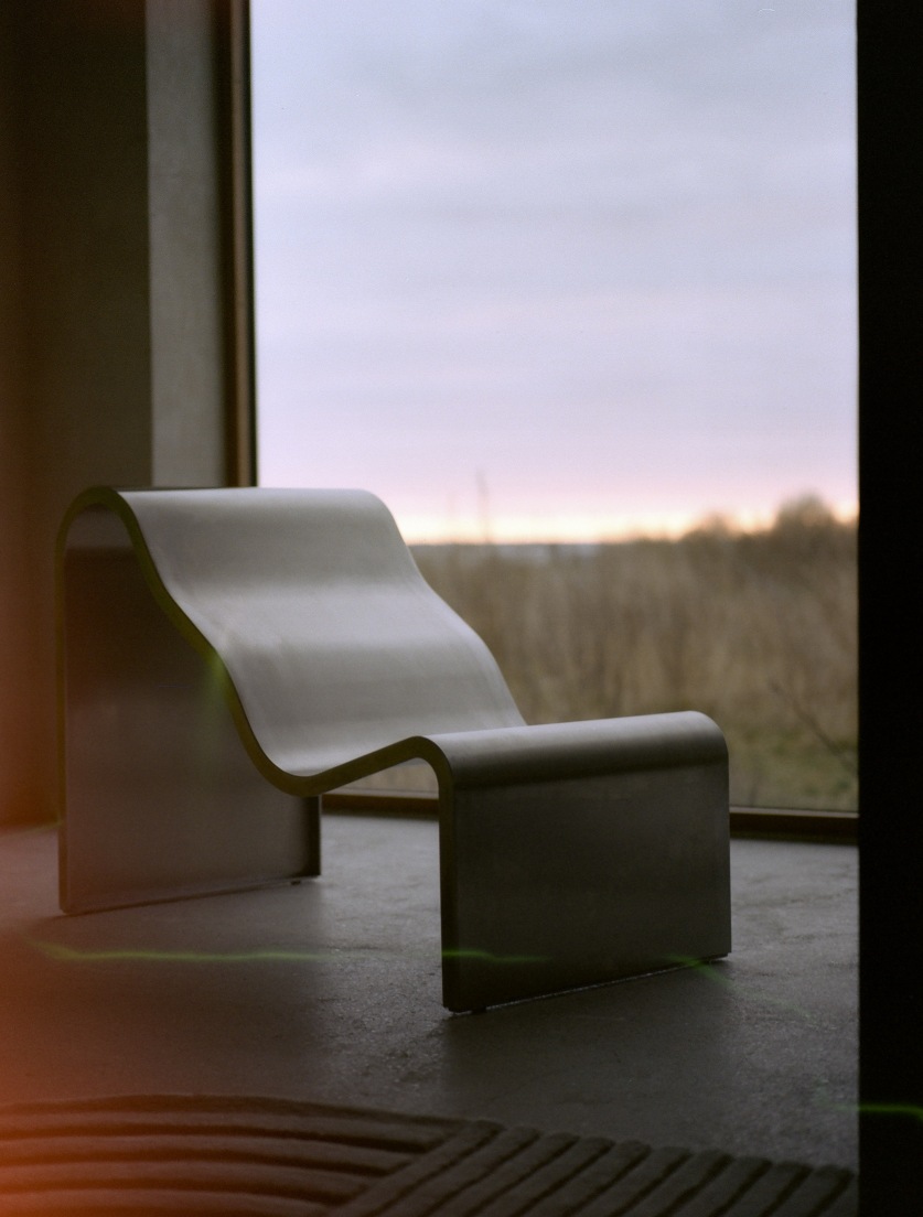 Muuto Dream Bench Indoor/Outdoor Bank vor einem Fenster mit Blick auf eine Landschaft.