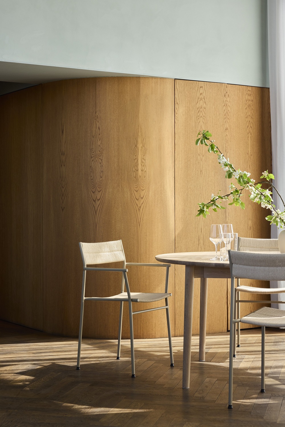 Vev Dining Armlehnstuhl von Northern an Esstisch mit Gläsern, stilvolles Esszimmer-Interieur.