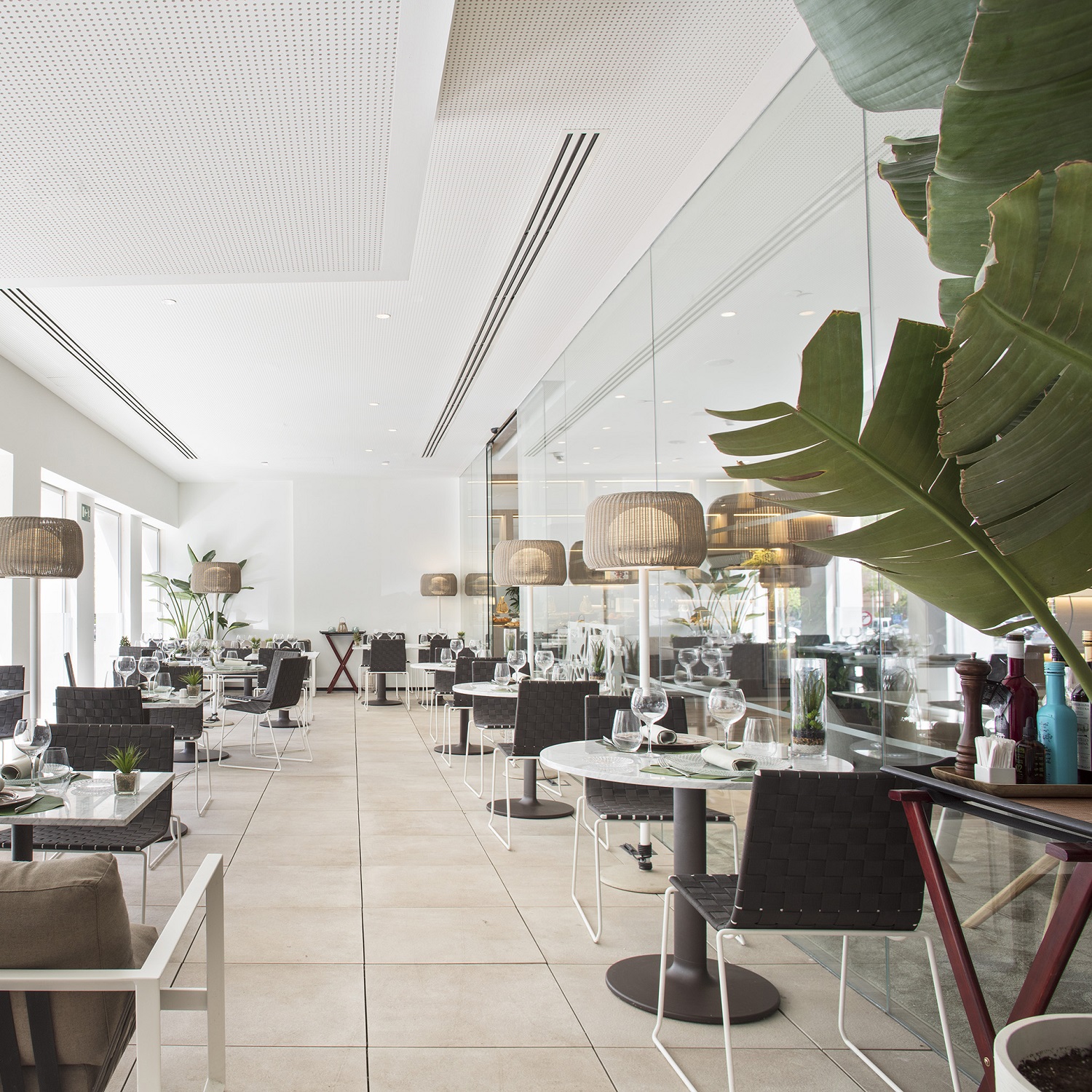 Innenansicht eines Restaurants mit Trenza SI0700 Outdoor Stühlen von Andreu World und gedeckten Tischen.