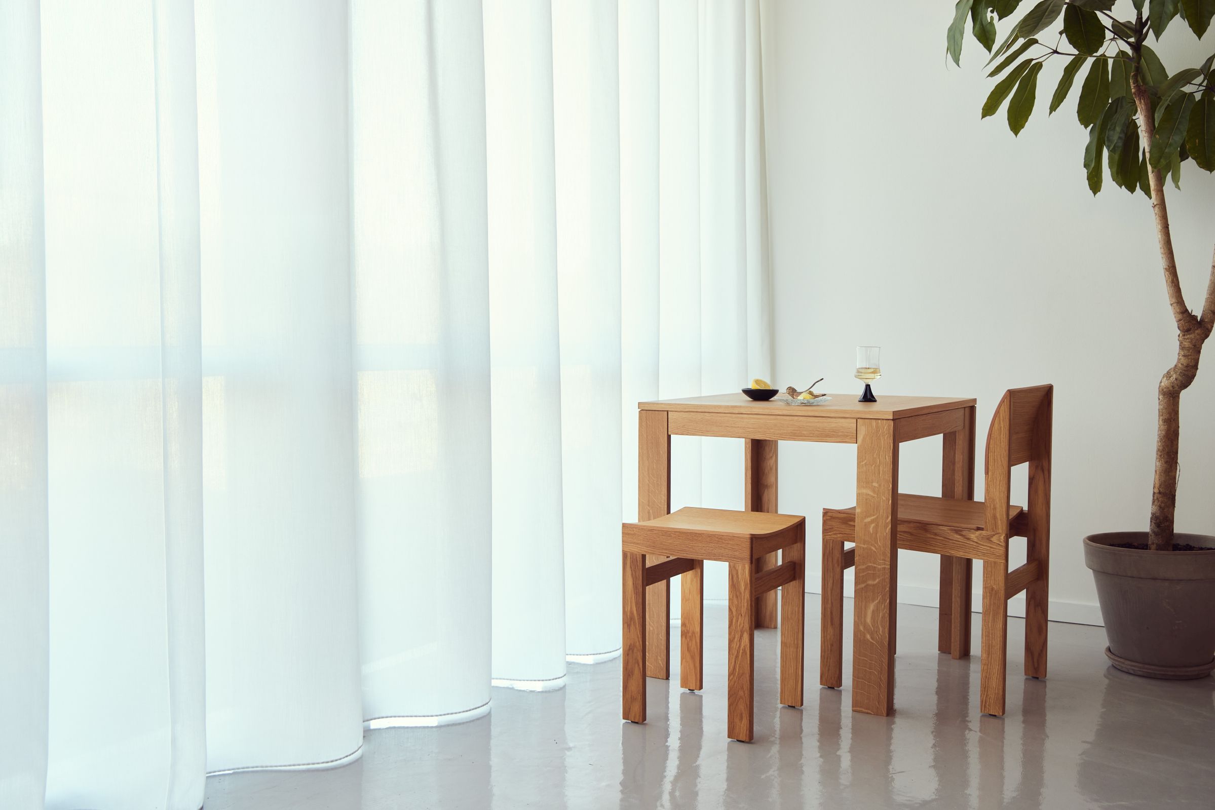 Sonder Stuhl Form & Refine aus Eiche mit passendem Tisch und Hocker im minimalistischen Design.