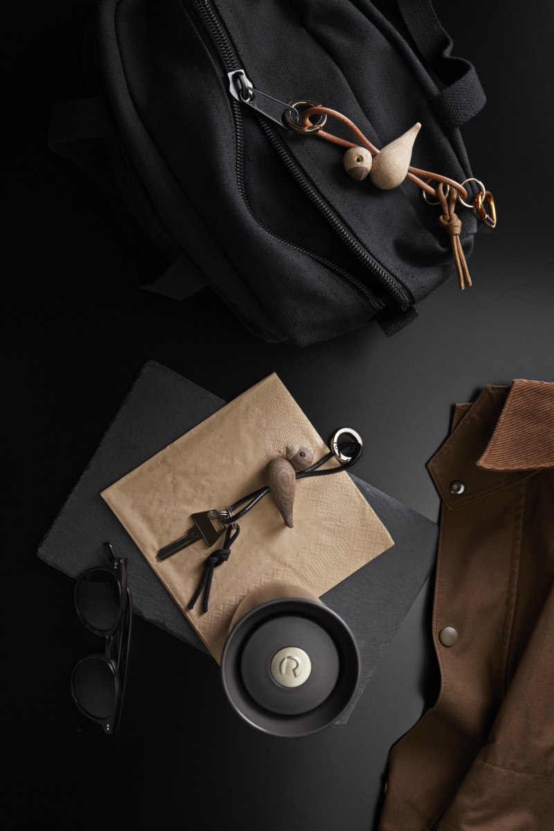 Produktfoto: Kay Bojesen Vogel Eiche Schlüsselanhänger aus Metall und Leder mit Schlüssel, Tasche und Jacke.