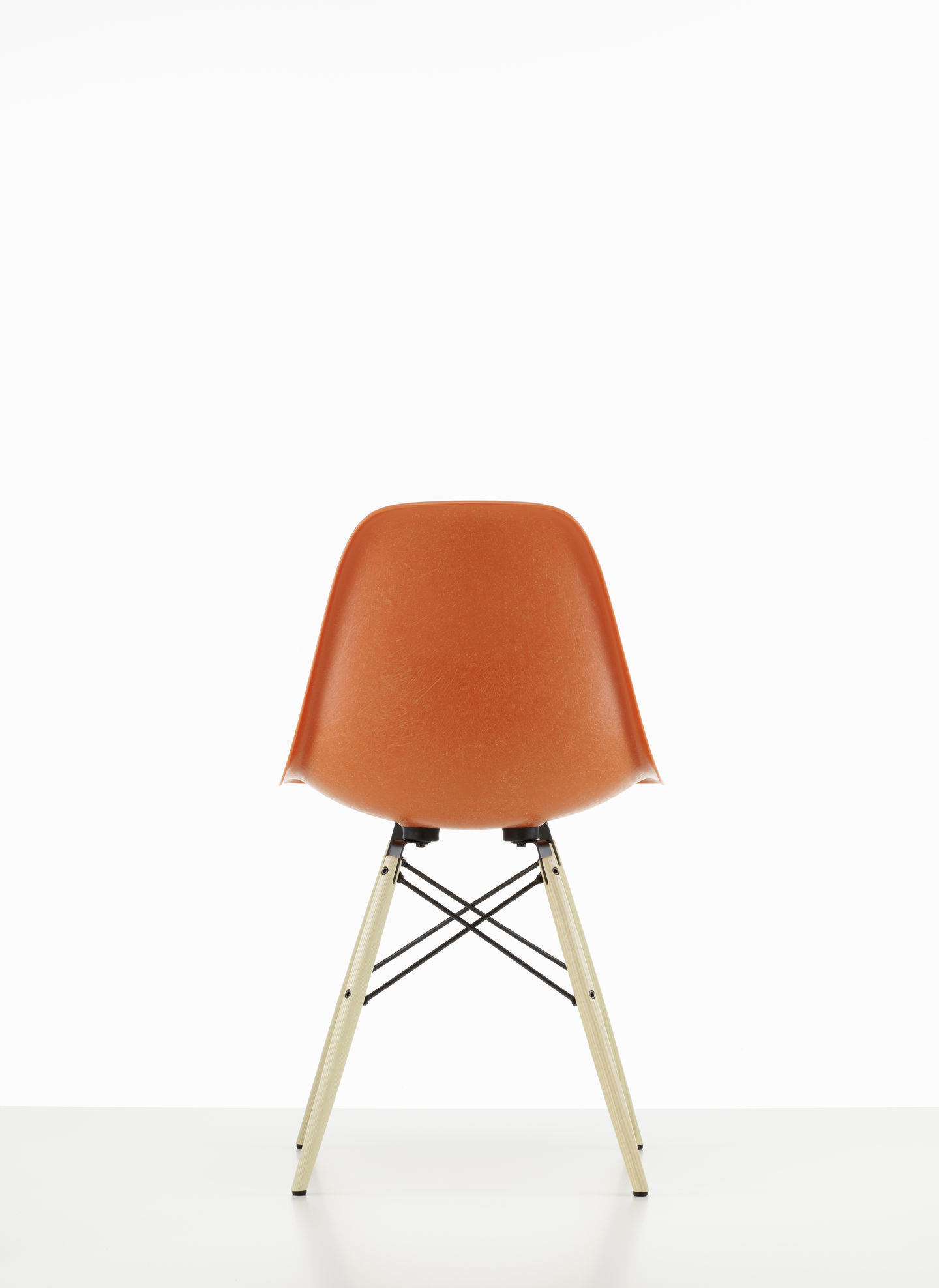 Rückansicht: Eames Fiberglass Chair DSW Stuhl von Vitra, orangefarbene Sitzschale, Holzbeine. Designklassiker.