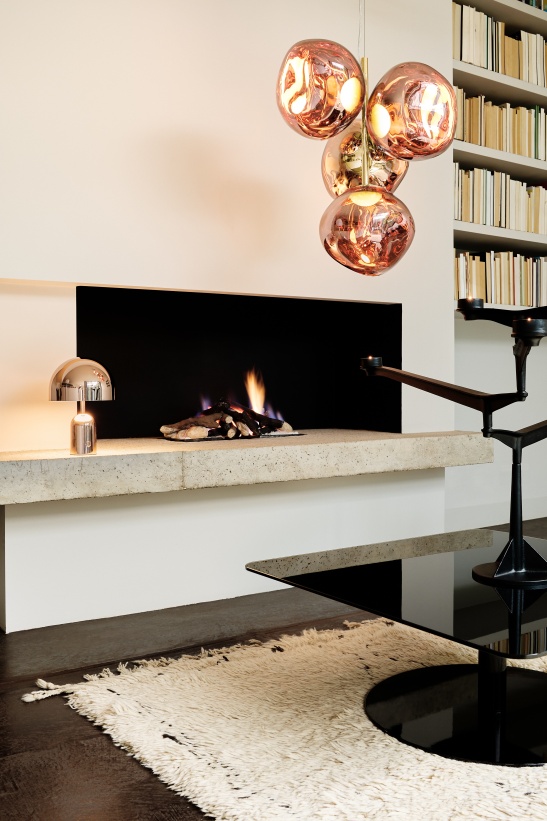 Modernes Wohnzimmer mit Tom Dixon Spin Kerzenständer, Kamin, Lampe und Bücherregal für stilvolle Inneneinrichtung.