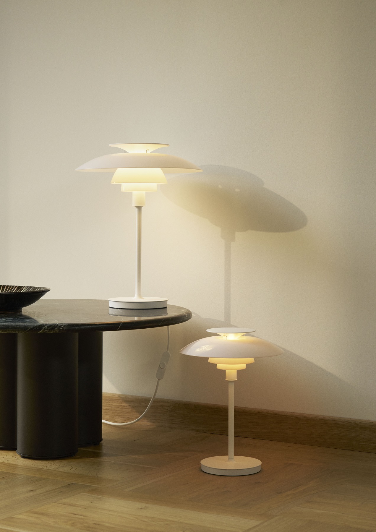 PH 80 Tischleuchte von Louis Poulsen, zwei weiße Design-Lampen auf Tisch und Boden.