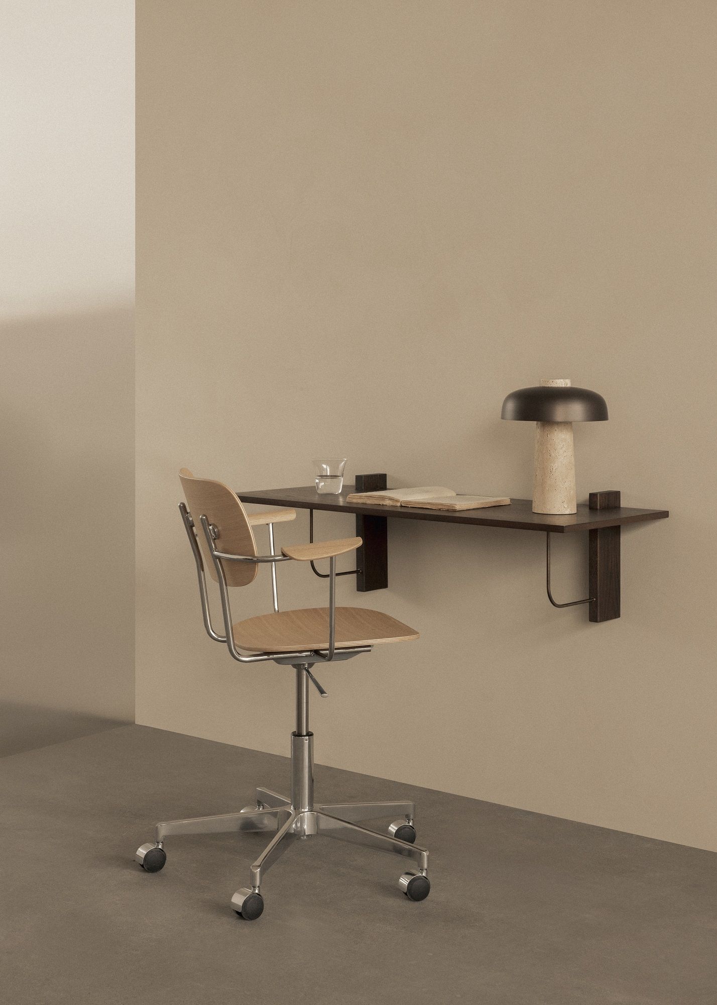 Corbel Wall Desk von Audo Copenhagen mit Stuhl, Lampe und Buch in minimalistischem Interieur.