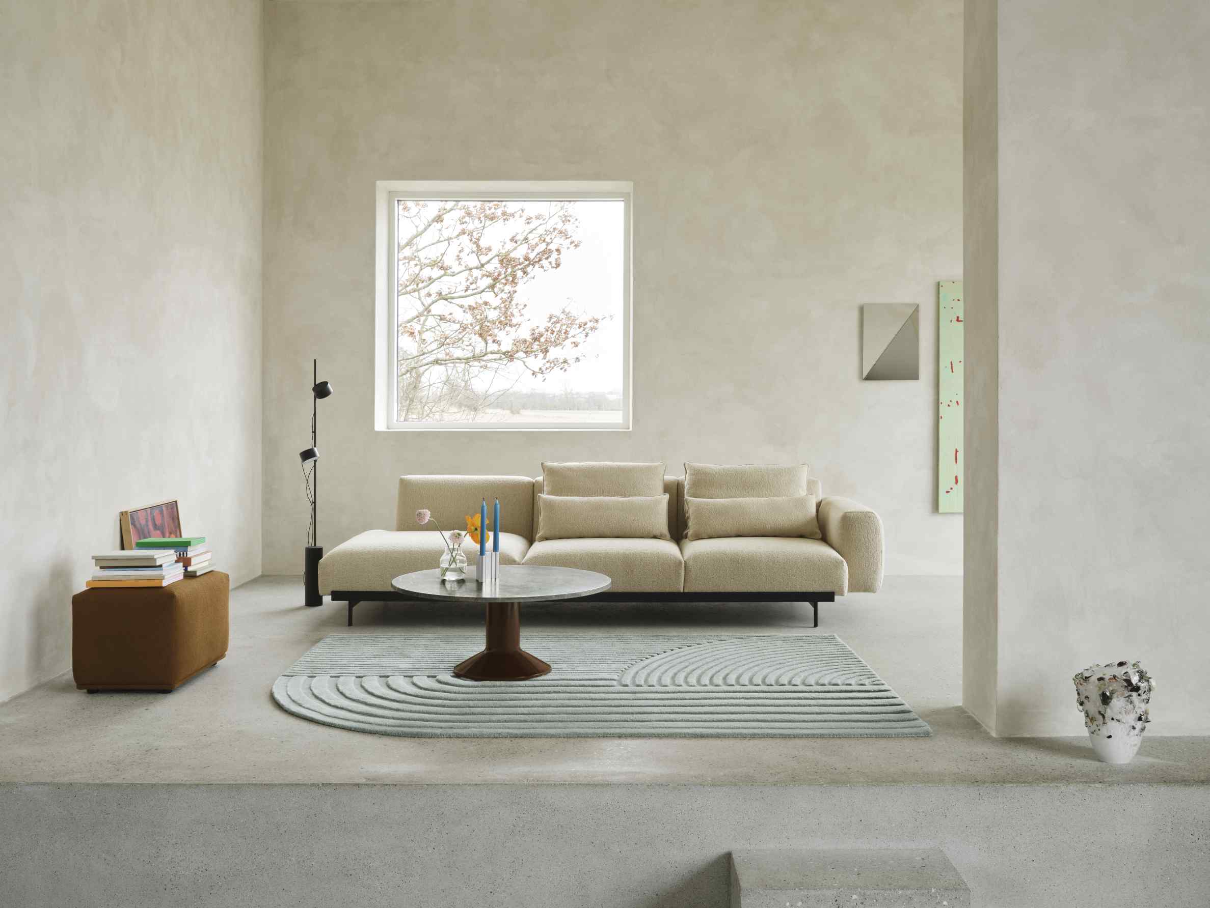 Heller Wohnraum mit beigem Sofa, Teppich und rundem MIDST Coffee Table Couchtisch von Muuto.