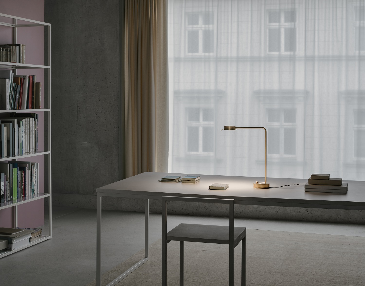w102 B Chipperfield Tischleuchte von wästberg auf Schreibtisch mit Büchern vor Fenster.
