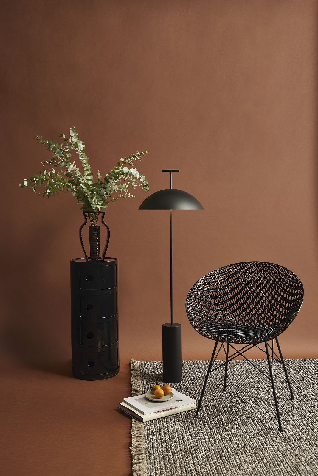 Schwarzes Kartell Componibili 4-er Element als Nachttisch mit Vase und Dekoration in modernem Ambiente.