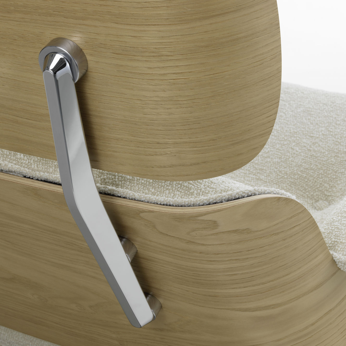 Detailaufnahme: Eames Lounge Chair Sessel von Vitra, helle Holzschale mit verchromtem Metallelement und beigem Stoffbezug.
