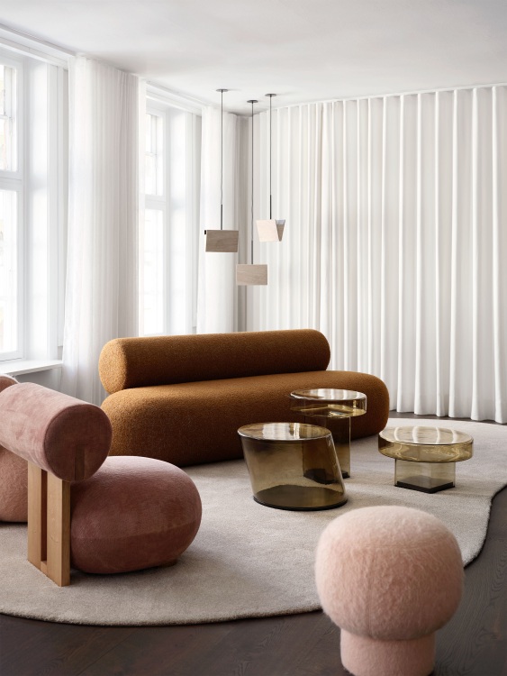 Wohnzimmer-Szene mit braunem Hippo Lounge Chair Sessel von NORR11 und passenden Möbeln auf Teppich.