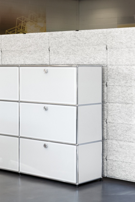 Weißes USM Haller Sideboard mit drei Fächern und grauen Privacy Panels als Raumteiler im Hintergrund.