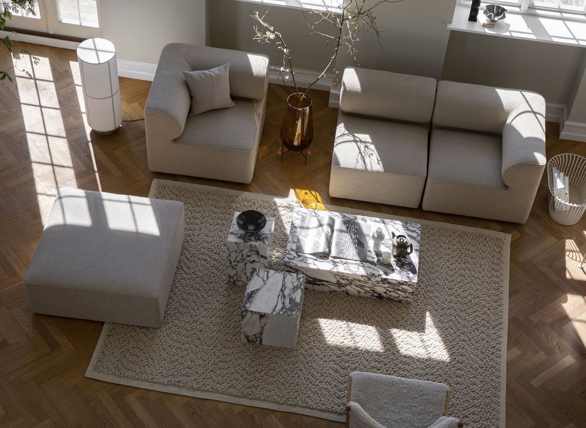 Beiger Gravel Rug Teppich von Audo Copenhagen in einem hellen Wohnzimmer mit Designermöbeln.