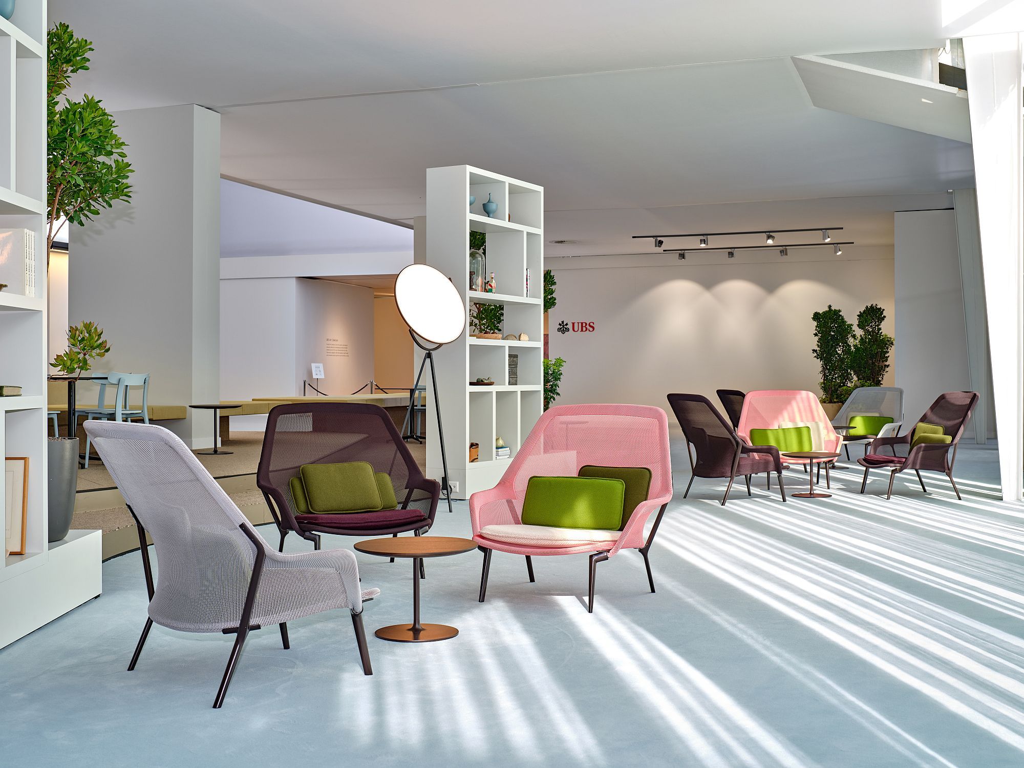 Ausstellungsraum mit mehreren Slow Chair Sesseln von Vitra in verschiedenen Farben und einem kleinen Beistelltisch.