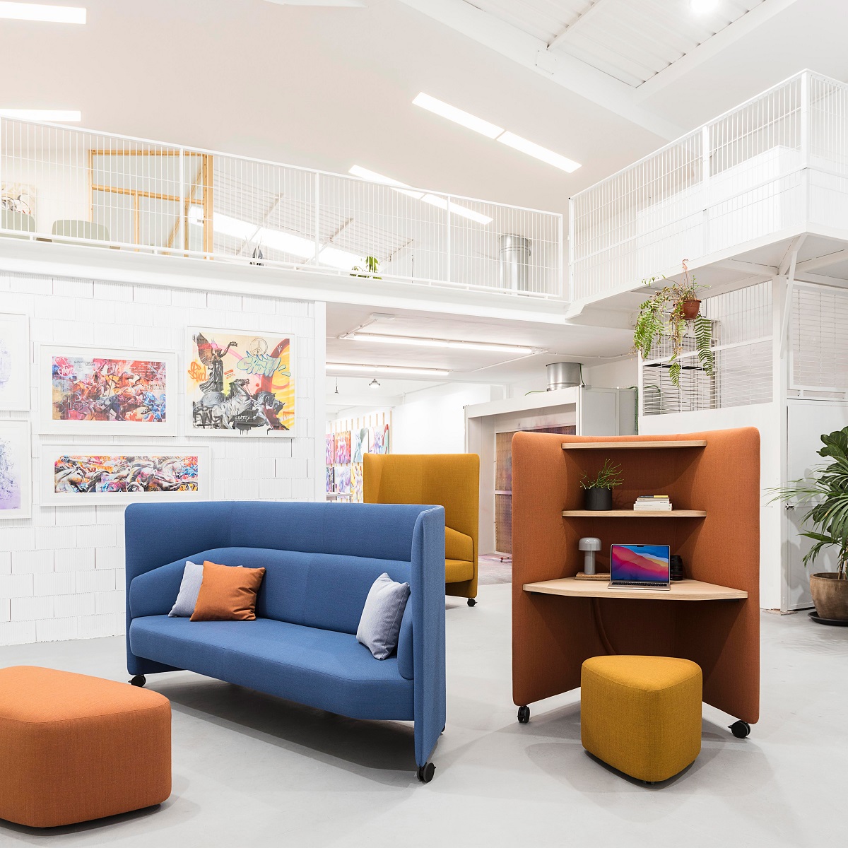 In Out Office ME2261: Moderner Büroraum mit blauem Sofa, orangefarbenem Schreibtisch mit Schallschutz und Sitzhockern.