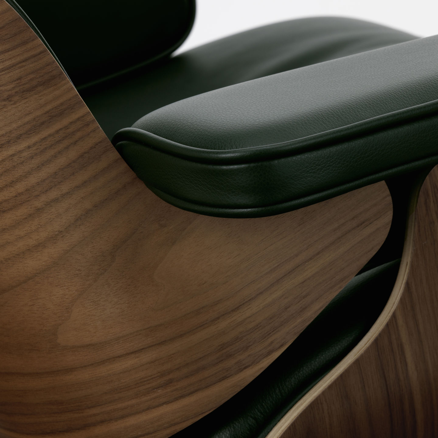 Detailaufnahme Eames Lounge Chair Sessel von Vitra: Walnussholz und grünes Leder, Armlehne im Fokus.