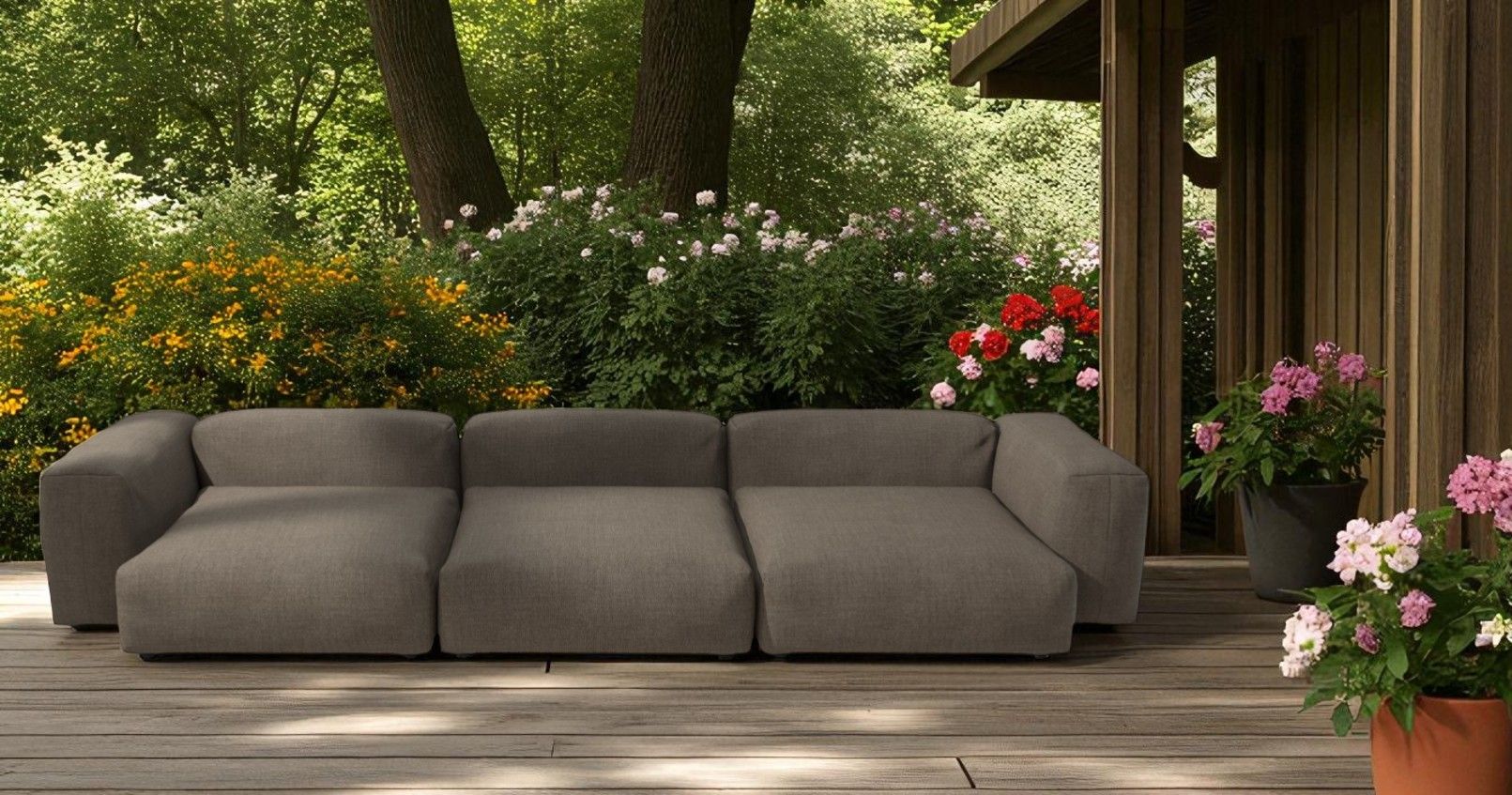 Vetsak Sofa Set 05 Outdoor 5-Sitzer in Grau auf Holzterrasse vor üppigem Garten.
