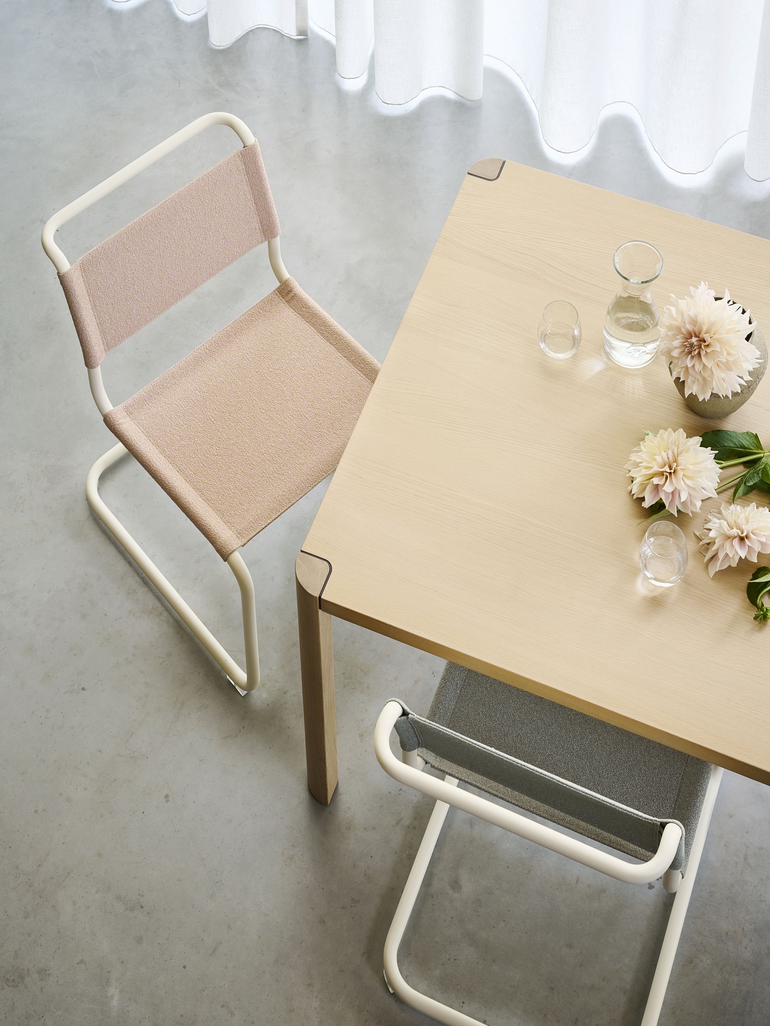S 33 Freischwinger Stühle von Thonet in Beige und Grau an einem Esstisch mit Blumendekoration.