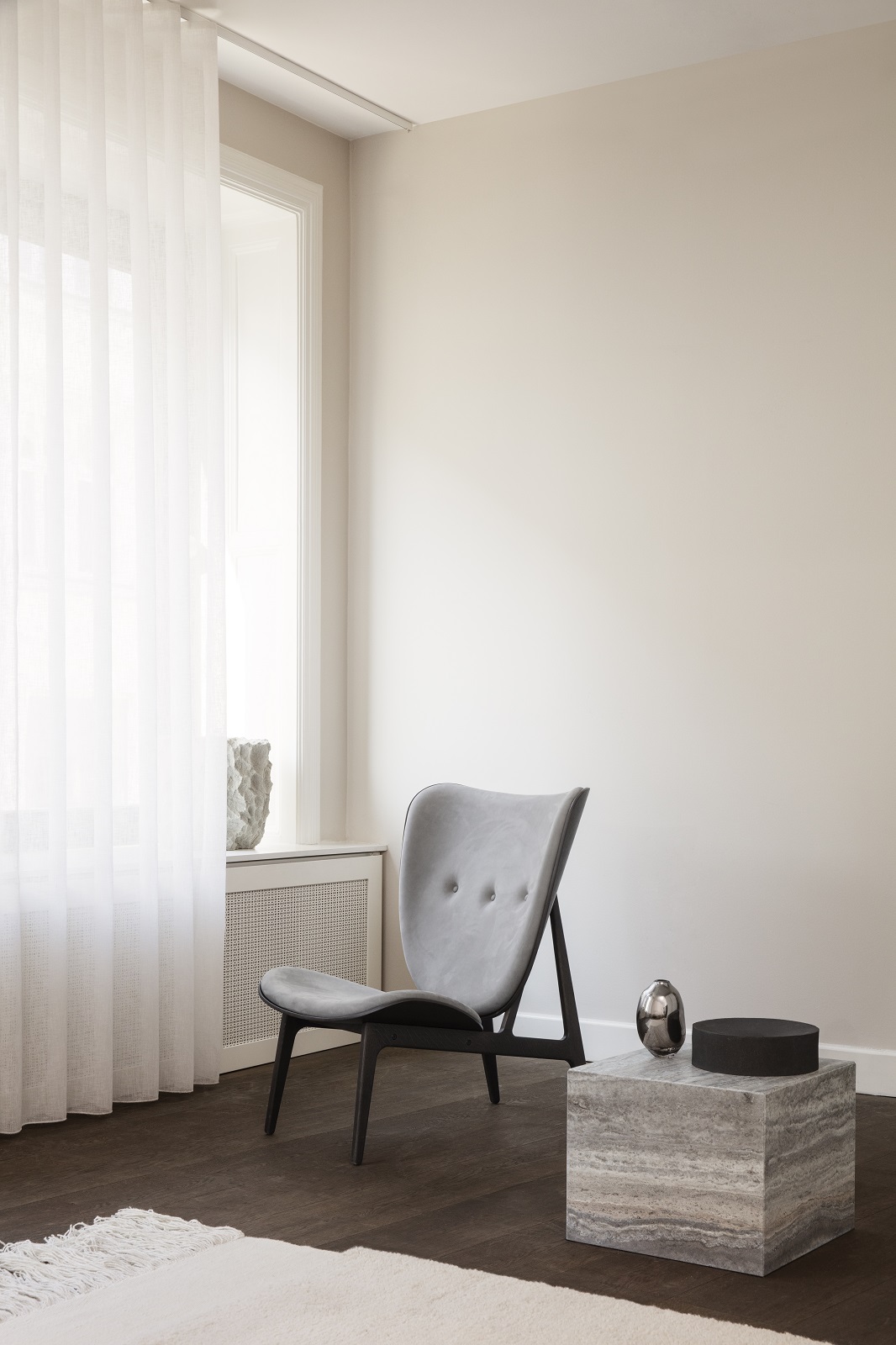 Cubism Coffee Table von Norr11, kleiner Couchtisch aus Travertin im minimalistischen Wohnzimmer mit Sessel.