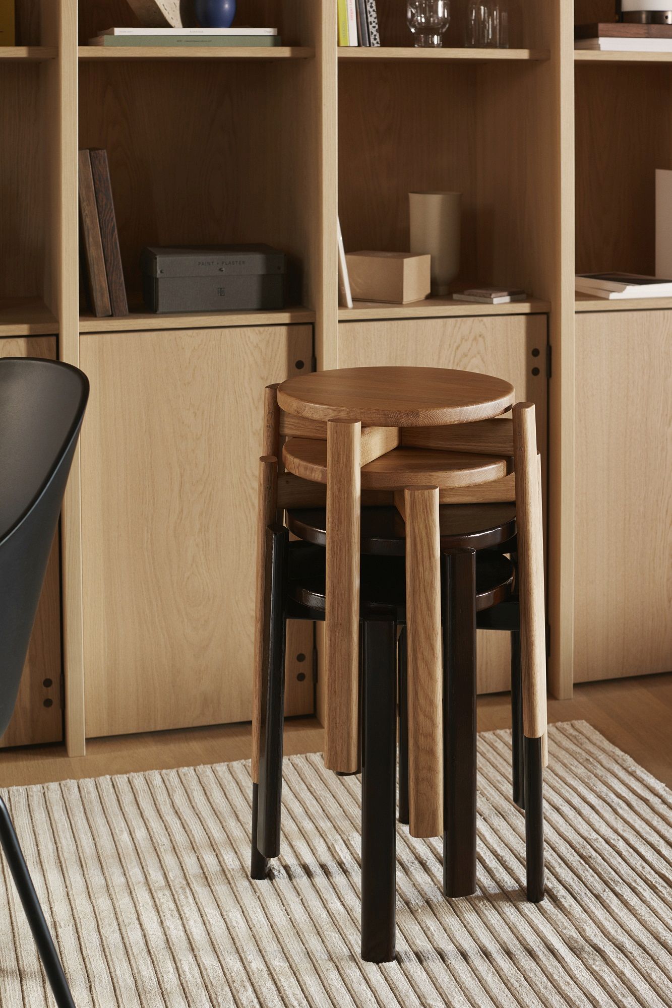 Gestapelte Audo Copenhagen Passage Hocker aus Holz und dunklem Holz, minimalistisches Design.