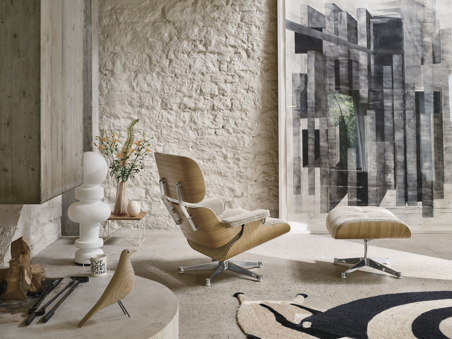 Eames Lounge Chair mit Ottoman von Vitra in hellem Holz und Stoffbezug im modernen Wohnzimmer.