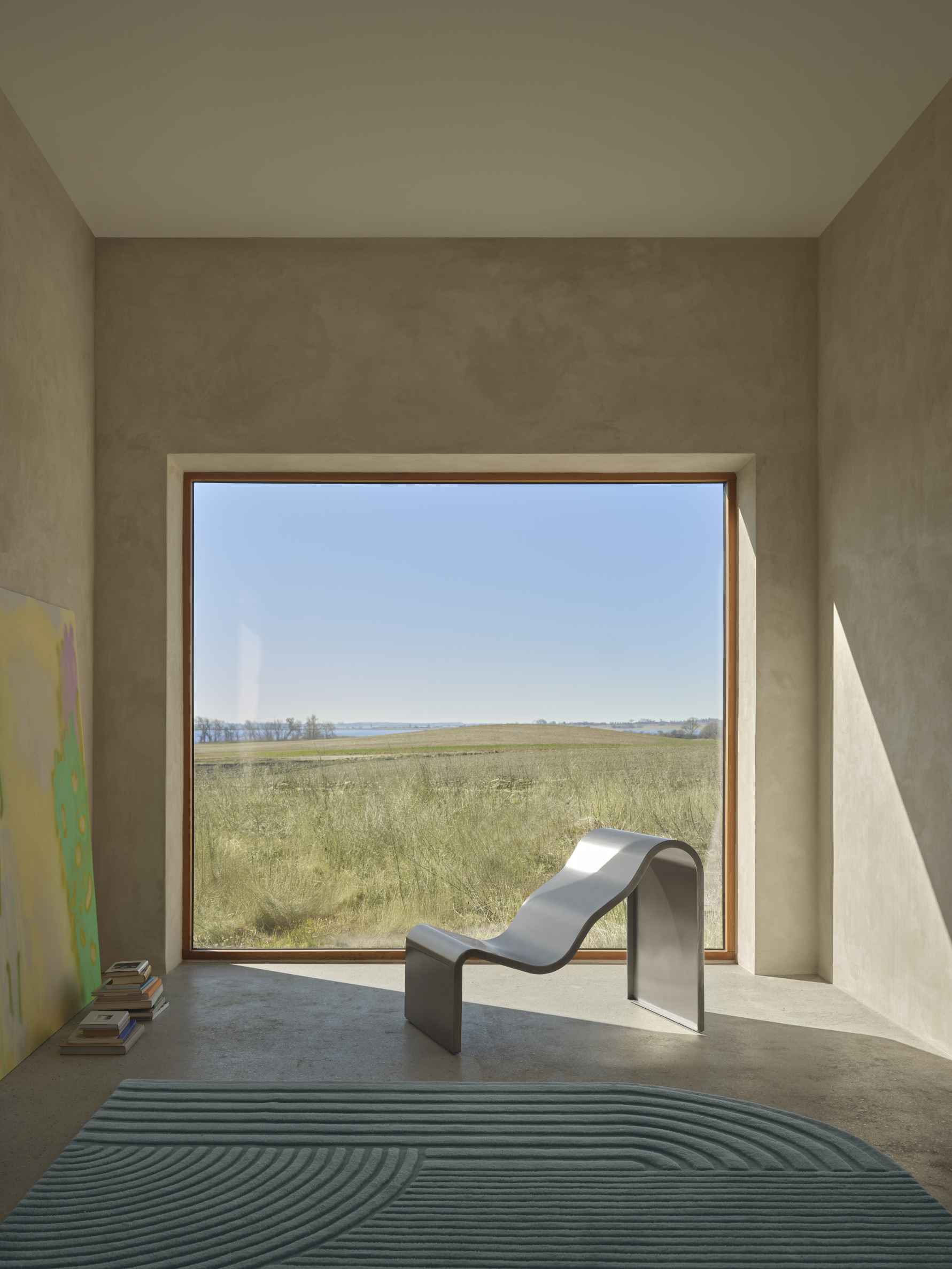 Helle Inneneinrichtung mit Dream Bench Bank von Muuto, minimalistisches Design, Blick auf grüne Landschaft durch großes Fenster.