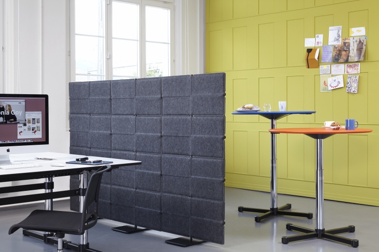 Grauer USM Haller Sichtschutz im Büro, der Privatsphäre schafft und als Raumteiler dient.