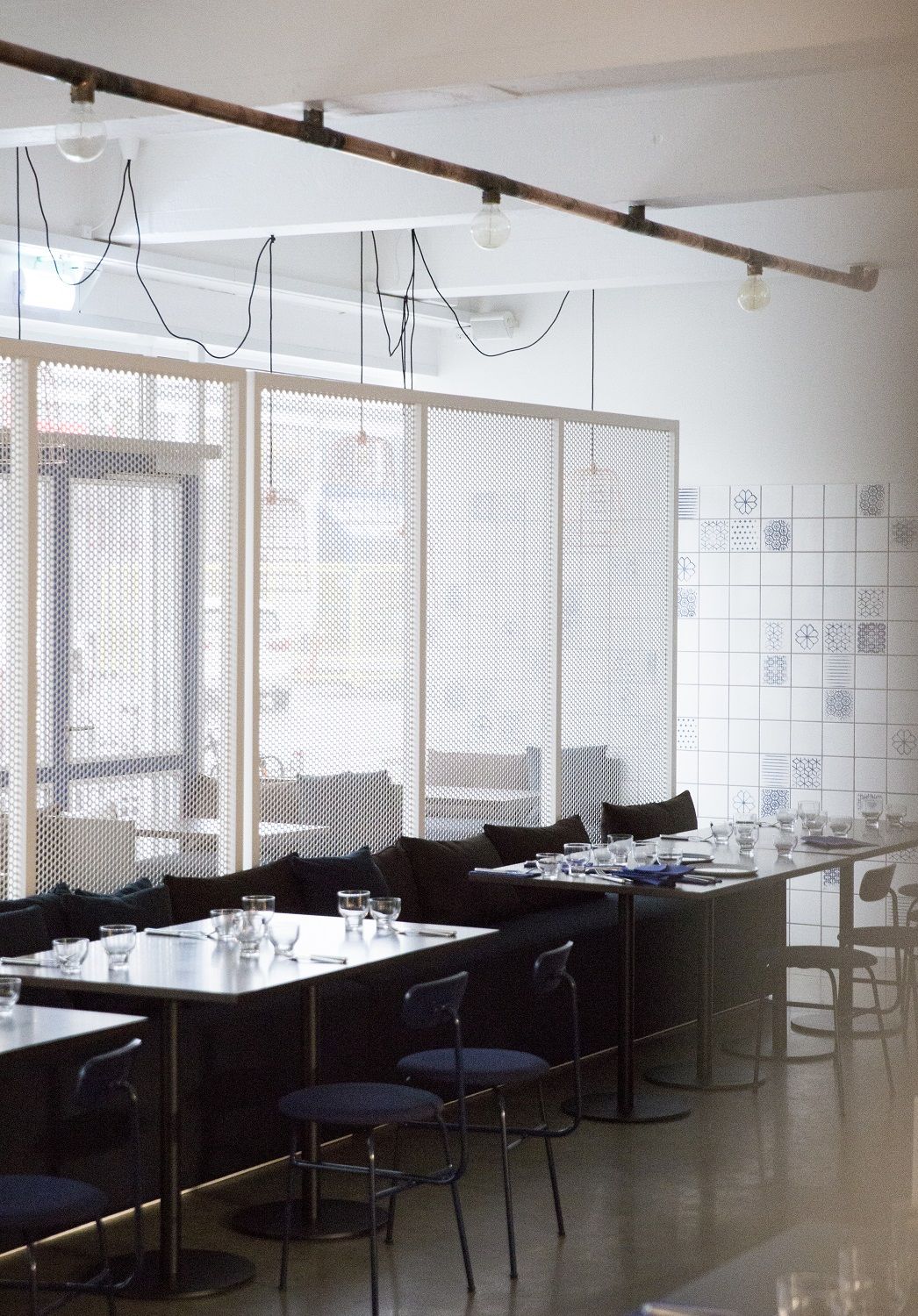 Innenaufnahme eines Restaurants mit gedeckten Tischen und Audo Copenhagen Afteroom Dining Chairs Stühlen in blau.