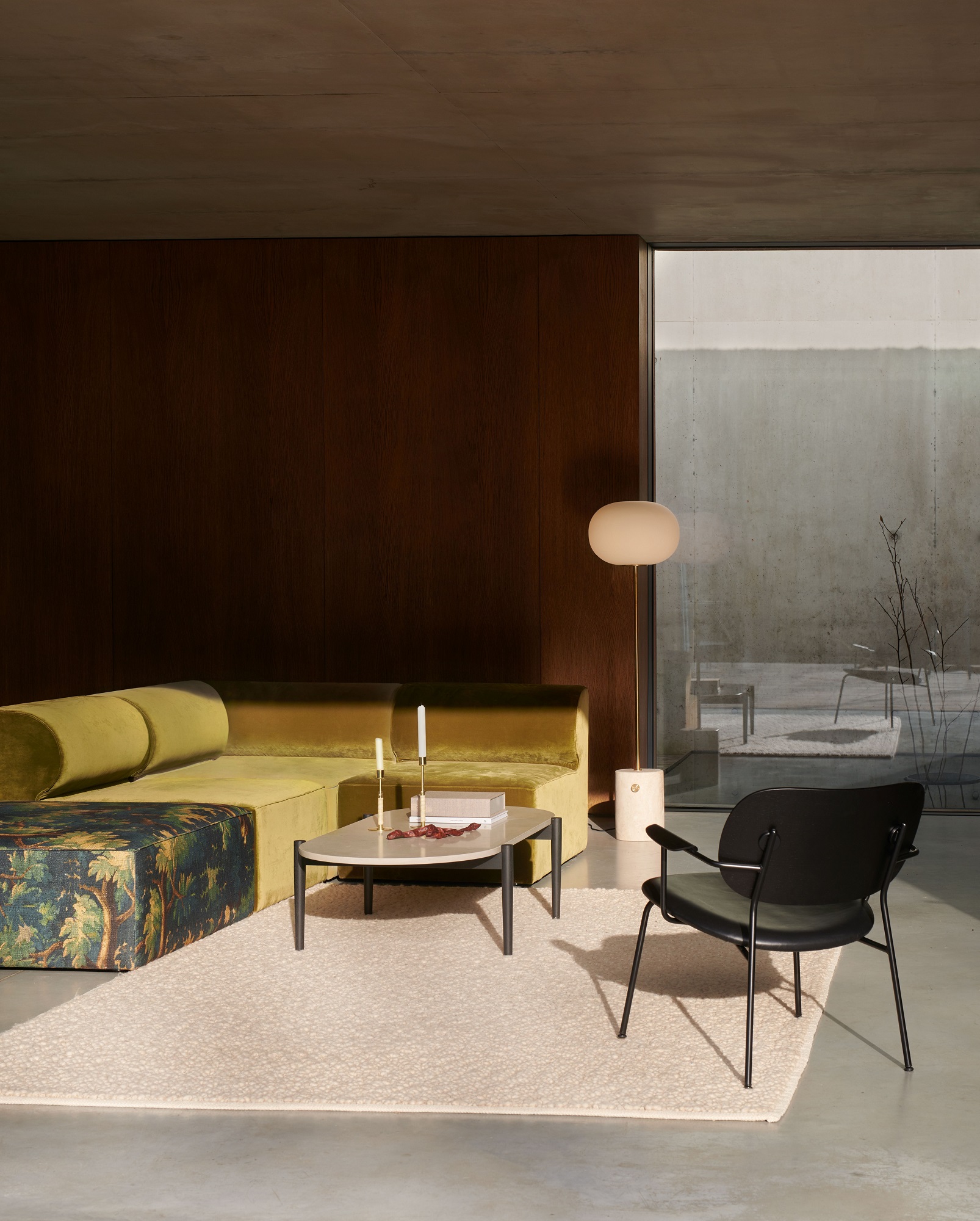 Audo Copenhagen Gravel Rug Teppich in hellem Beige im modernen Wohnzimmer mit Sofa und Sessel.