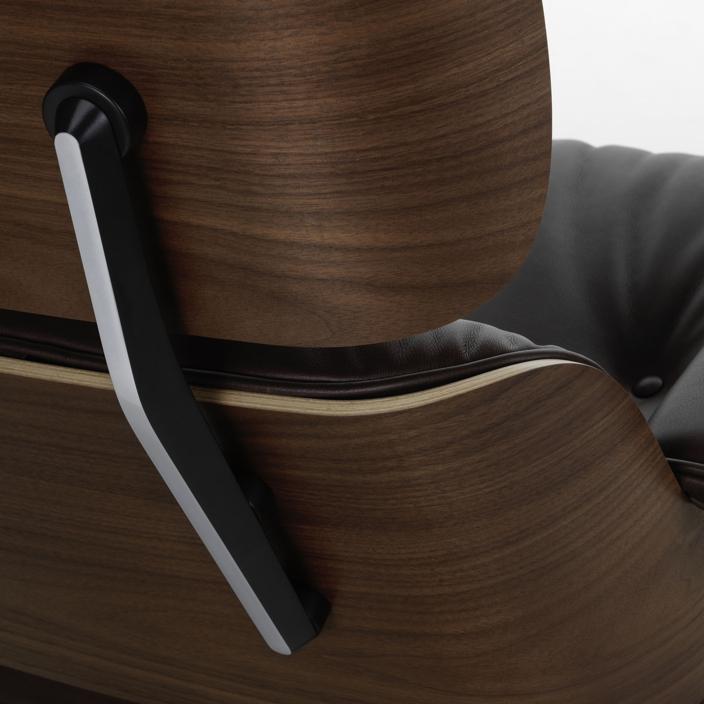 Detailaufnahme des Eames Lounge Chair Sessels von Vitra, mit Armlehne und braunem Lederbezug.