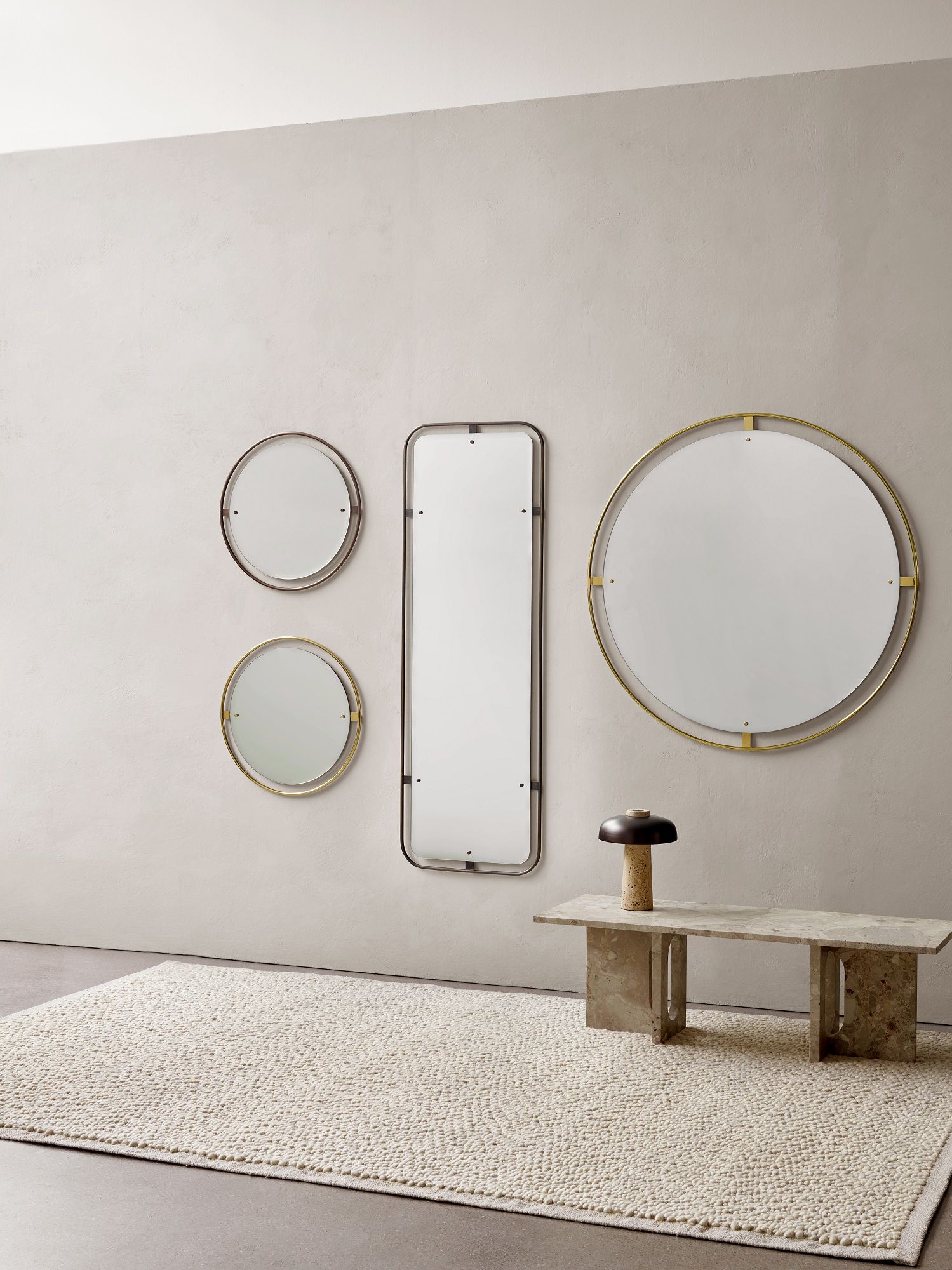 Audo Copenhagen Nimbus Mirror Set in verschiedenen Größen und Rahmenfarben an einer Wand.