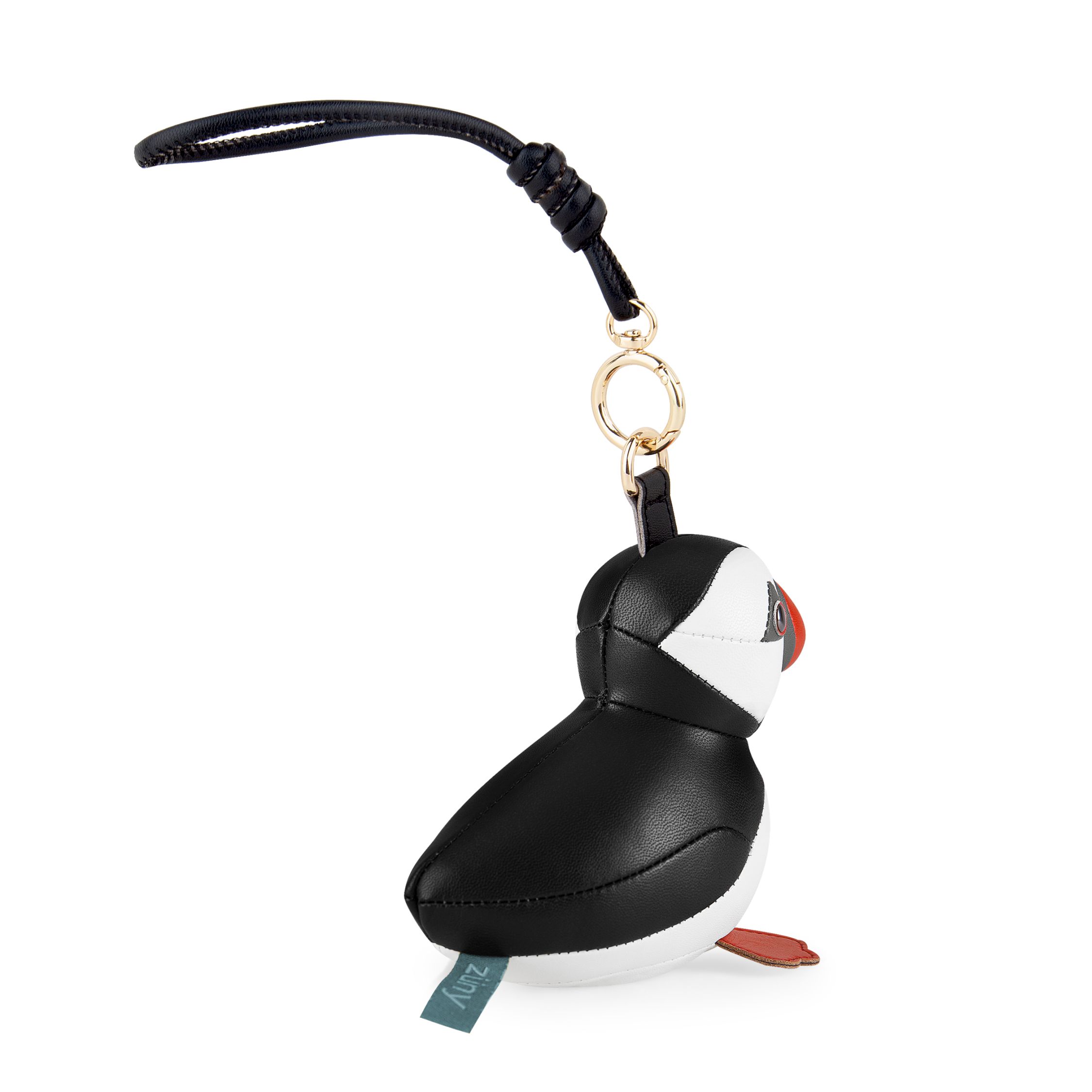 Detailaufnahme des Züny Puffin Taschenanhängers: Schwarzer und weißer Leder-Vogel mit rotem Schnabel und Füßen.