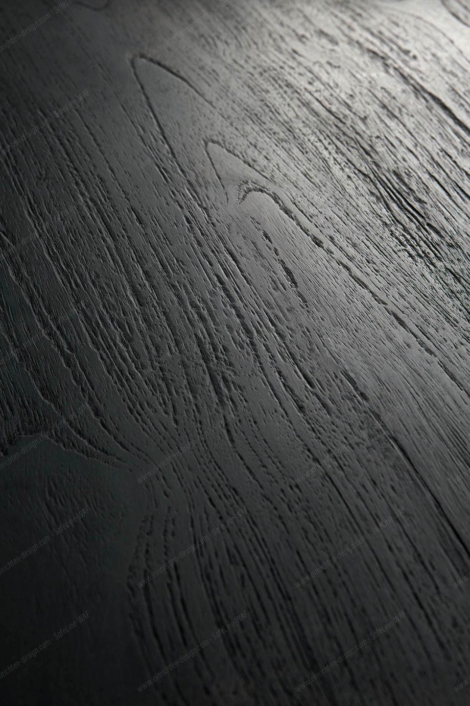 Detailaufnahme der schwarzen Eichenholz-Tischplatte des Tripod Beistelltisches von Ethnicraft, Fokus auf die markante Holzmaserung.