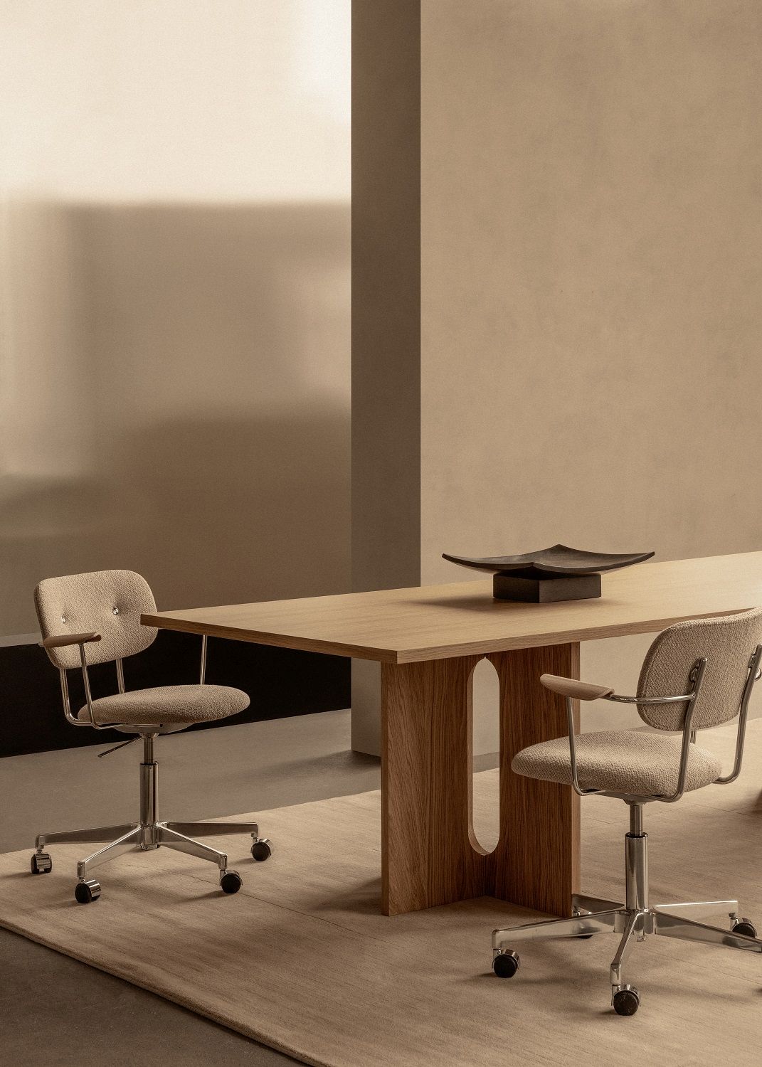 Co Task Chair Bürostuhl von Audo Copenhagen in Beige mit Armlehnen und Rollen vor Holztisch.
