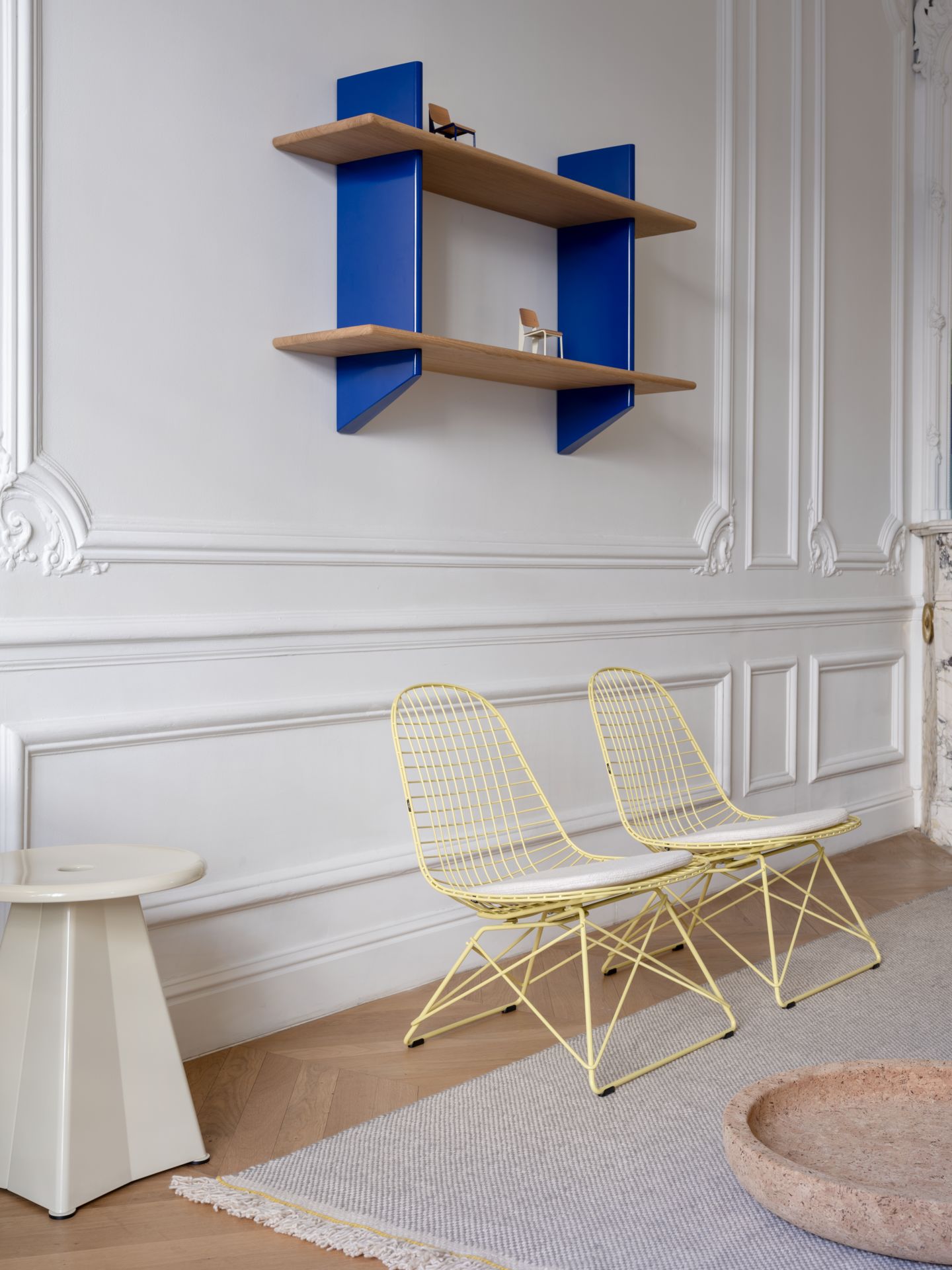 Zwei gelbe LKR-2 Wire Chairs von Vitra mit Sitzbezug in einem stilvollen Wohnzimmer.