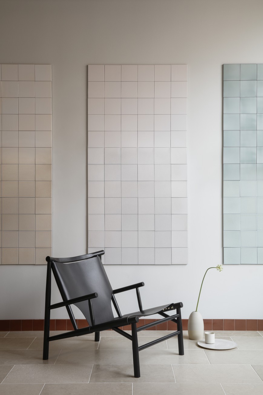 Schwarzer Samurai Sessel von NORR11 mit Lederbezug und Holzgestell vor Wandfliesen. Design Lounge Chair.