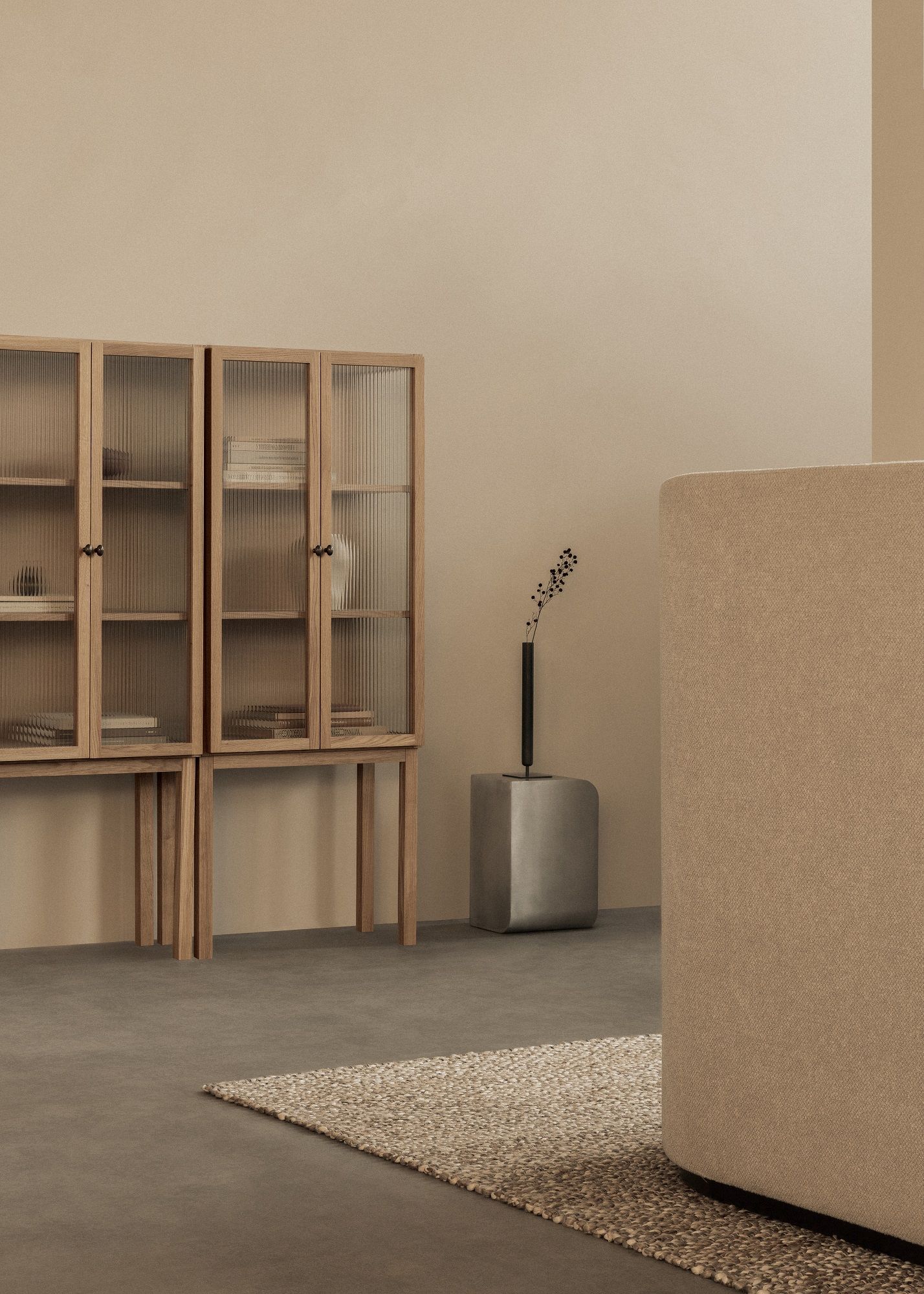 Audo Copenhagen Curiosity Cabinet Low, ein Holzschrank mit geriffelten Glastüren im minimalistischen Wohnzimmer.
