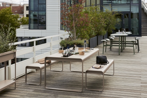 Fermob Bolder Outdoor Tischgruppe mit Sitzbänken auf einer Dachterrasse, ideal für den Garten.