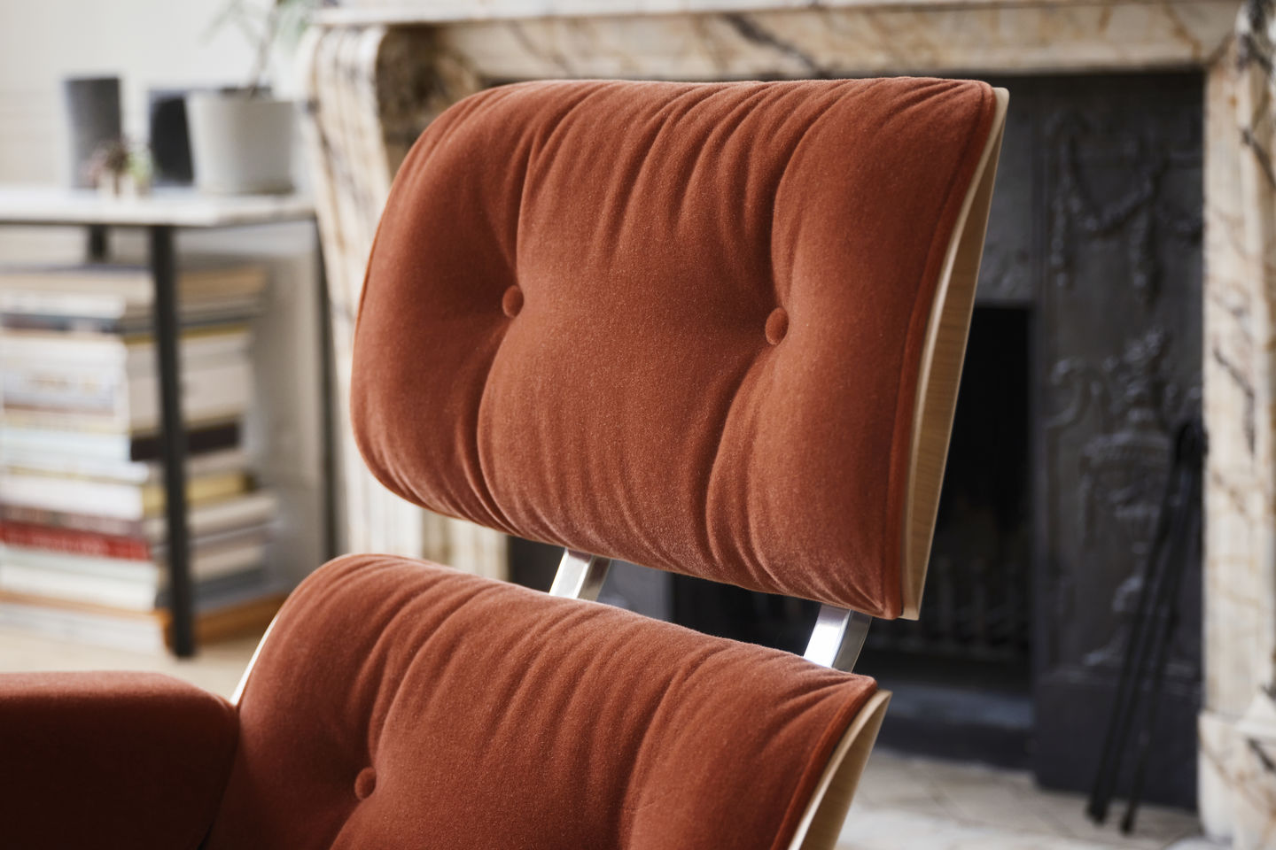 Detailaufnahme: Eames Lounge Chair mit Ottoman in braunem Stoffbezug und Holzrahmen, Designklassiker von Vitra.
