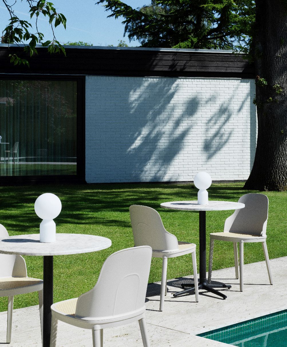 Yo Lamp Small Tischleuchte von Normann Copenhagen im Garten auf einem runden Tisch.