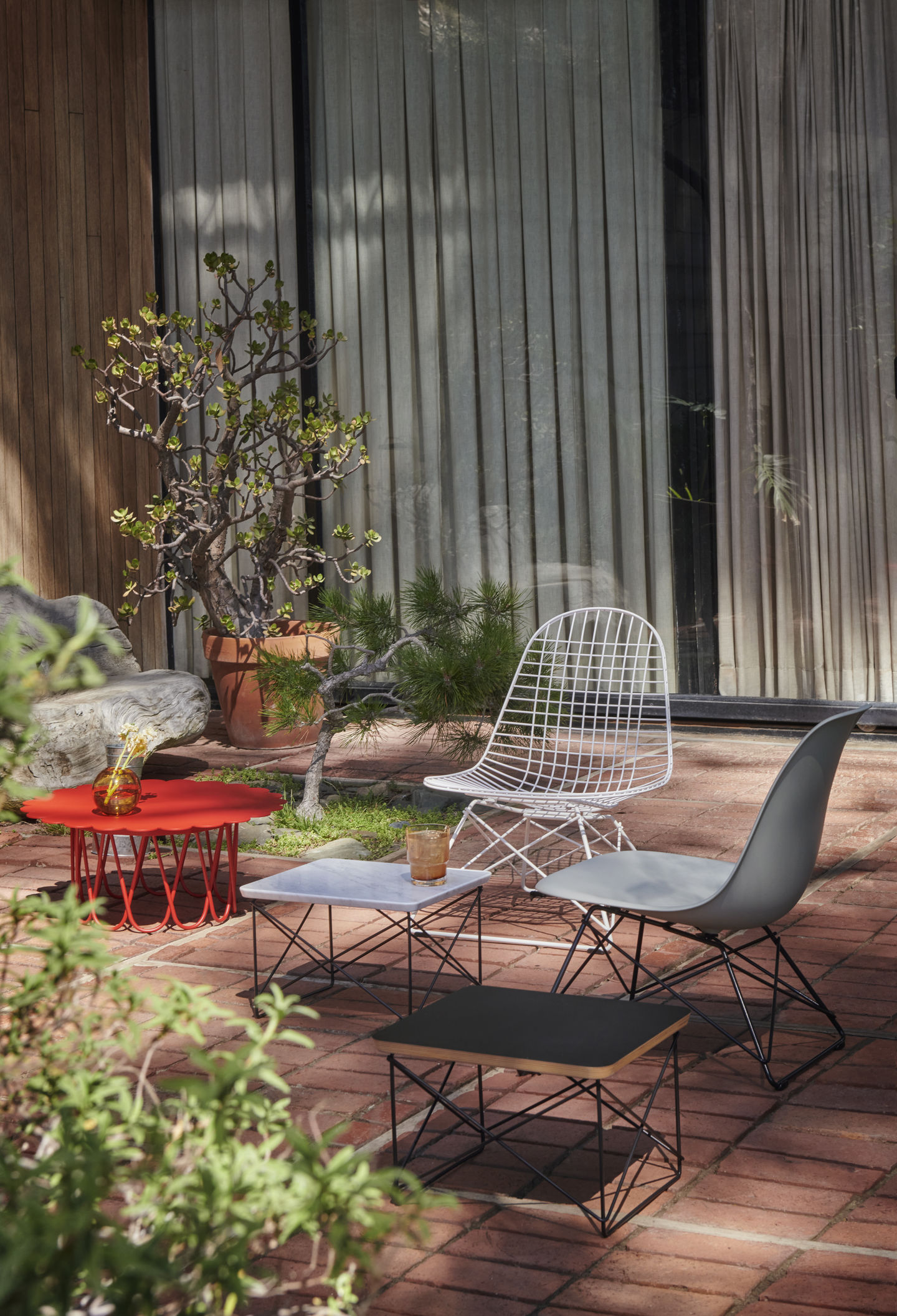 Vitra LKR-2 Wire Chair Stuhl mit Sitzbezug und verschiedene Design Beistelltische im Garten.
