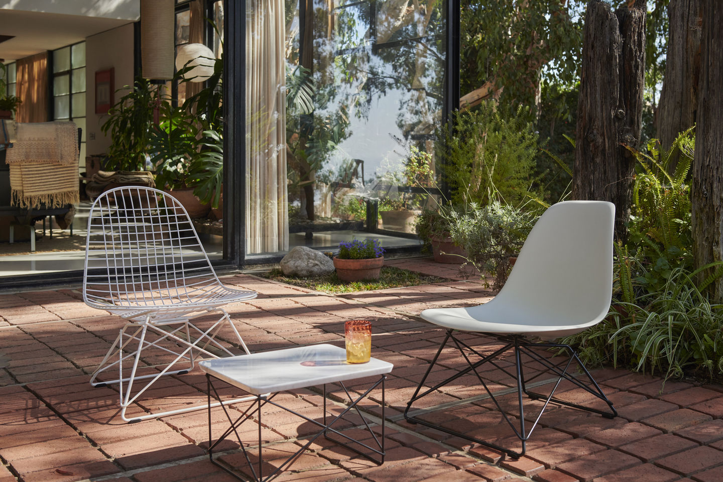 Vitra LKR-2 Wire Chair Stuhl und Eames Plastic Chair im Garten mit Beistelltisch.